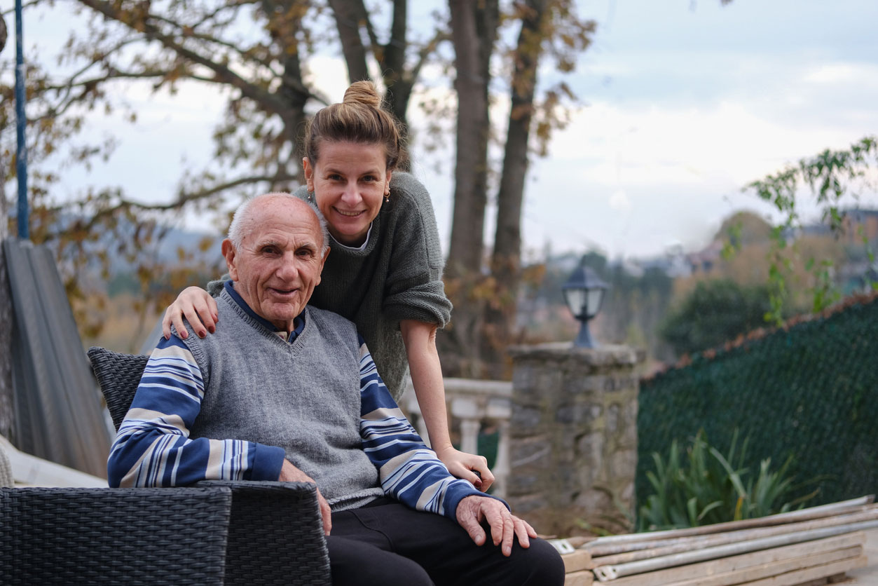 A young woman and elderly man smiling