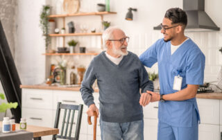 A caregiver helping a senior man to stand up