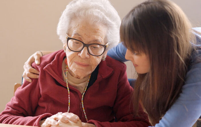A young woman with her arm around an elderly woman